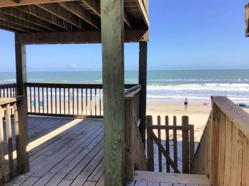 a wooden boardwalk leading to a beach with the ocean at Paradise Point - Barefoot Beachfront Living in Surfside Beach