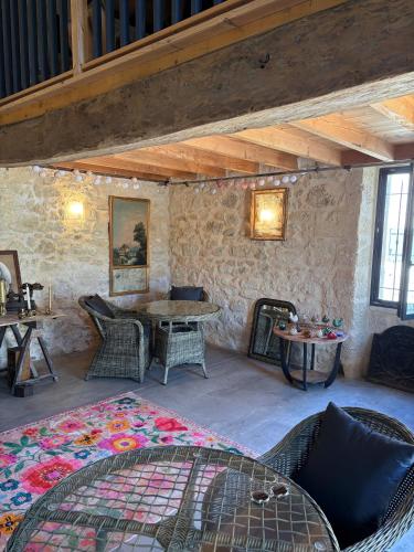 a room with a table and chairs and a stone wall at Château Clos des Maurins in Vérac