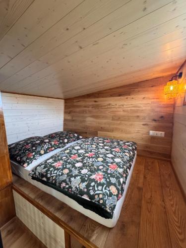 a bedroom with a bed in a wooden room at Tiny Haus Seeadler in Schwasdorf