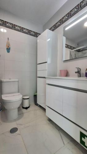 a white bathroom with a toilet and a sink at Da Rocha Beach 50M, AMAZING Sunset SEA VIEW in Portimão