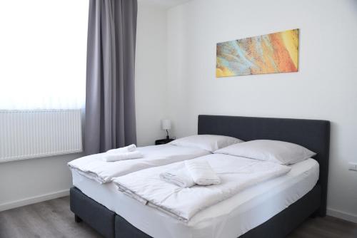 a bed with white sheets and pillows in a bedroom at Pension La Casa in Radolfzell am Bodensee