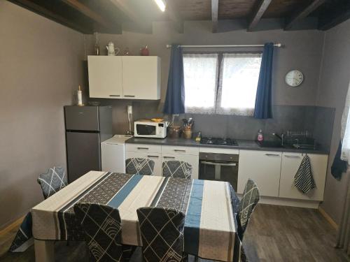 a small kitchen with a table and a microwave at Maison de campagne in Picherande