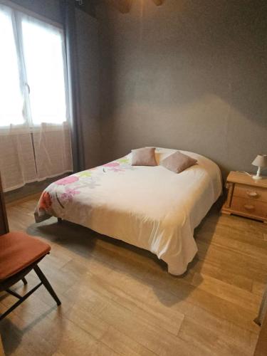 a bedroom with a bed with white sheets and a window at Maison de campagne in Picherande