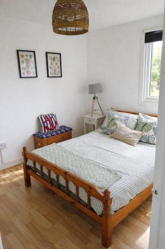 a bedroom with a bed and a chair and a window at Hillside Chalet in Kilkhampton