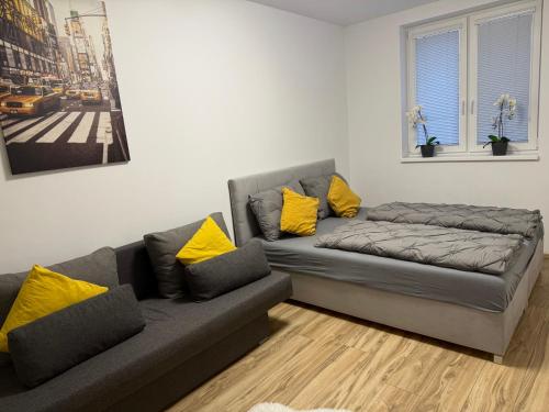 a living room with a couch and yellow pillows at Prestige Suite DS in Dunajská Streda