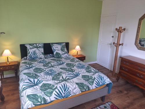 a bedroom with a bed with a blue and white comforter at chambre d'hôte in Saint-Rémy-en-Rollat