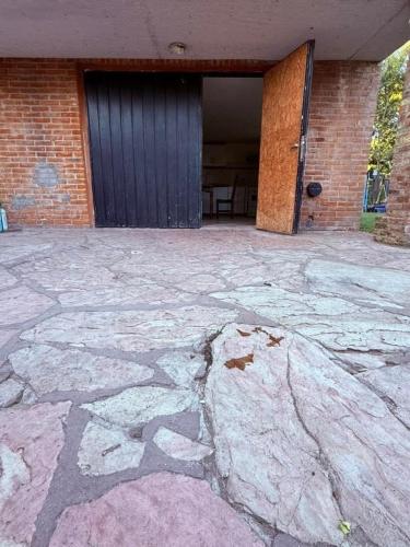 a building with a door and a stone patio at Lo de Nery in Ostende
