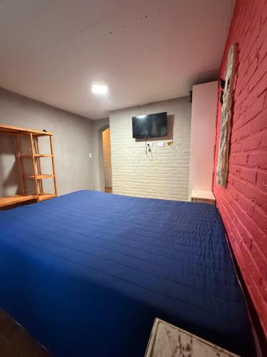 a bedroom with a blue bed and a red wall at Lo de Nery in Ostende