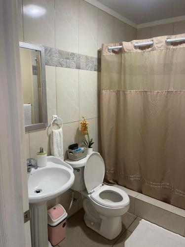 a bathroom with a toilet and a sink at The Colosseum St Kitts in Basseterre