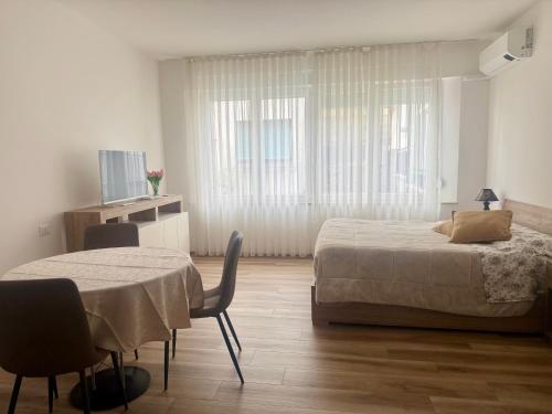 a bedroom with two beds and a table and chairs at Monolocale elegante e luminoso nel Centro Storico- A due passi da tutto in Pordenone