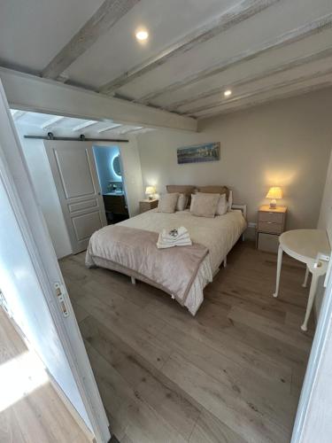 a bedroom with a large bed and a table at Le Blanc Spa in Nanteuil-en-Vallée