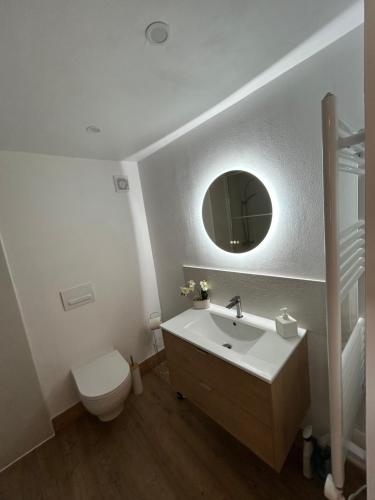 a bathroom with a sink and a toilet and a mirror at Le Blanc Spa in Nanteuil-en-Vallée