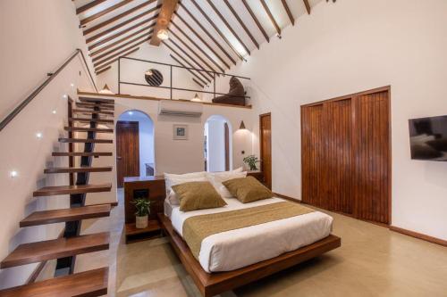 a bedroom with a bed and a stair case at Avora Lake Villas in Anuradhapura