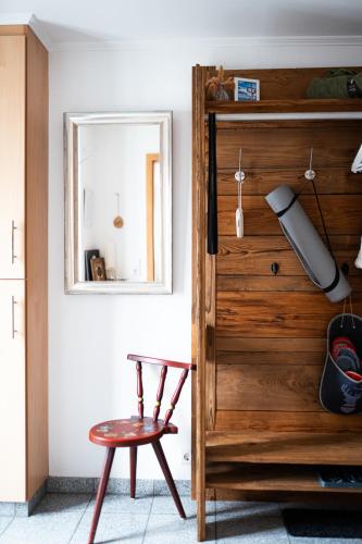 a mirror and a stool in front of a wooden door at Jules Ferienhaus im Allgäu mit Garten in Willofs