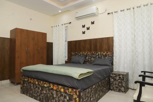 a bedroom with a large bed with a wooden headboard at Aashray in Dehradun