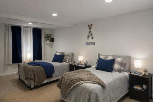 a bedroom with two beds with blue pillows at Cape Lake Private Beach Fire Table in Plymouth