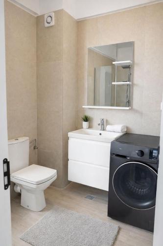 a bathroom with a washing machine and a sink at Apartament Meraki SeaView in Mamaia Sat/Năvodari
