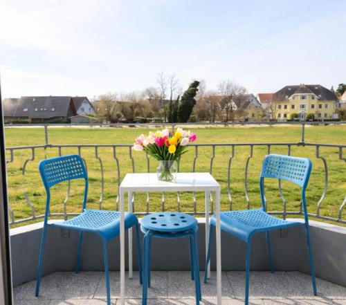a table and chairs on a balcony with a vase of flowers at NEU Apartmenthaus-Usedom Familie Stopp Kajüte 7 - Balkon - strandnah in Kölpinsee