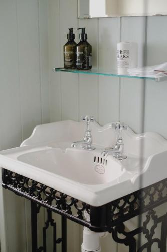 a bathroom with a white sink and a glass shelf at Clock View - Haworth in Haworth