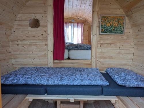 a bedroom with a bed in a wooden cabin at Schlaffass auf der Fischer-Ranch in Westerheim