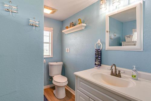 a blue bathroom with a toilet and a sink at 1 Block to Surfside Beach: Home w/ Deck! in Freeport