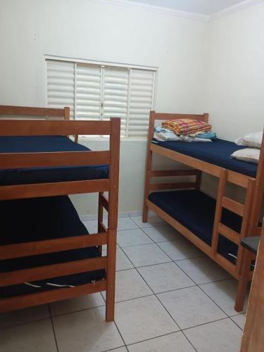 a room with two bunk beds and a window at Casa Amarela in Pouso Alegre