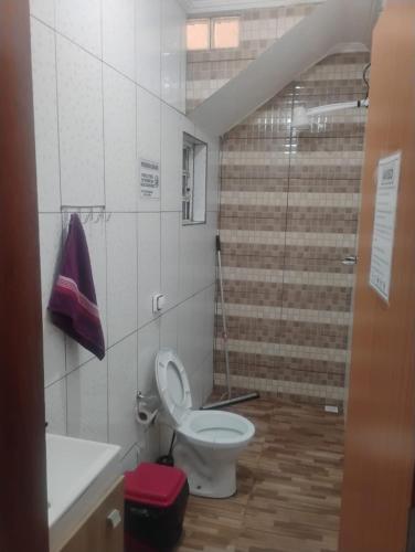 a bathroom with a toilet and a sink and a shower at Casa Amarela in Pouso Alegre