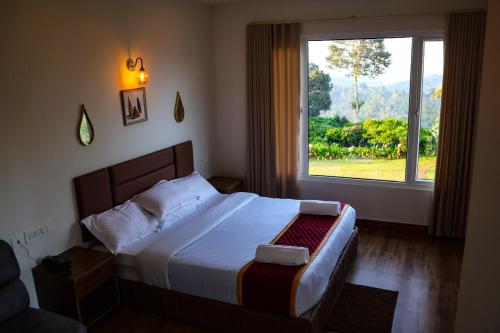 a bedroom with a bed with a large window at Misty Bean Resort in Meppādi