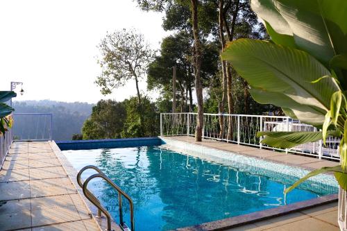 a swimming pool with a view of the water at Misty Bean Resort in Meppādi