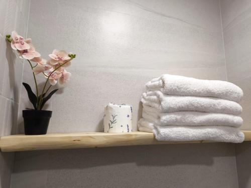 a bathroom shelf with towels and a vase of flowers at Hostería VISTAPARK in El Astillero