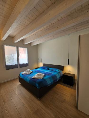 a bedroom with a blue bed and wooden ceilings at Case di Daniela in Chiavari