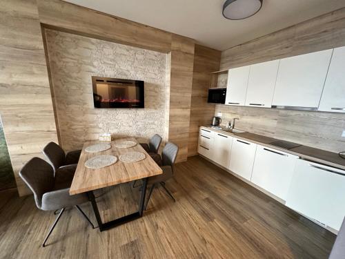 a kitchen and dining room with a table and chairs at Apartmán Tatrya in Vysoké Tatry