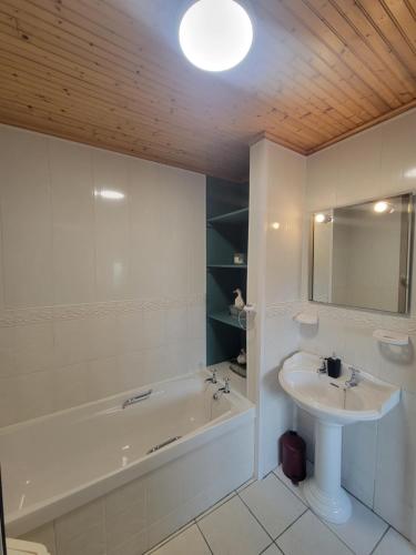 a bathroom with a tub and a sink and a bath tub at Spring Grove Guesthouse in Donegal