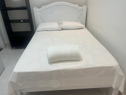 a white bed with white sheets and pillows on it at Suíte privativa in Boa Vista