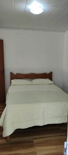 a bedroom with a large bed with a white comforter at Chalé da Helô in Nova Friburgo