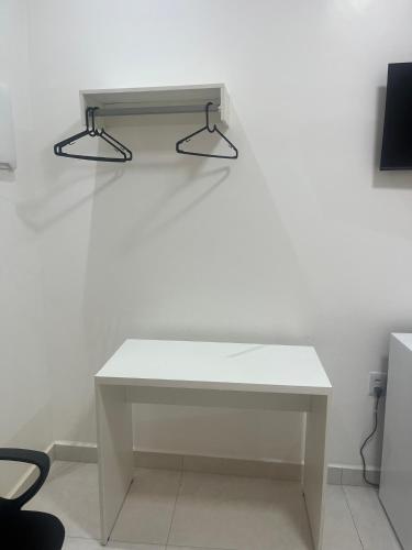 a white table with two lights on a white wall at Suíte privativa in Boa Vista