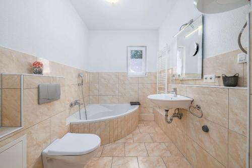 a bathroom with a tub and a sink and a toilet at Maleluni in Malinska