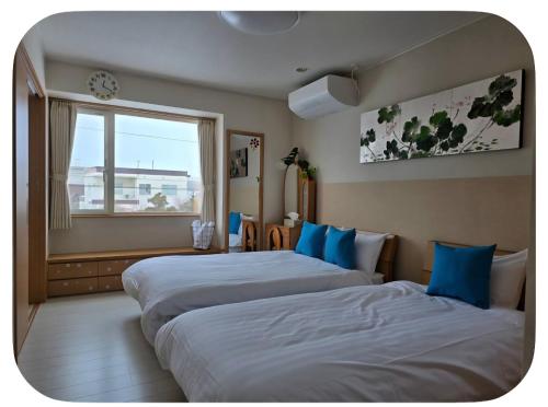 a hotel room with two beds and a window at Hokkaido Hakodate Onuma National Park Kenzo's House in Ōnuma