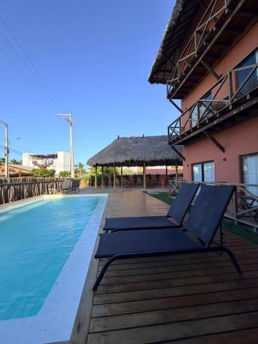 a deck with lounge chairs next to a swimming pool at BobZ Concept in Barrinha