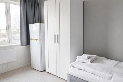 a white room with a refrigerator and a window at Rygge Apartments in Moss