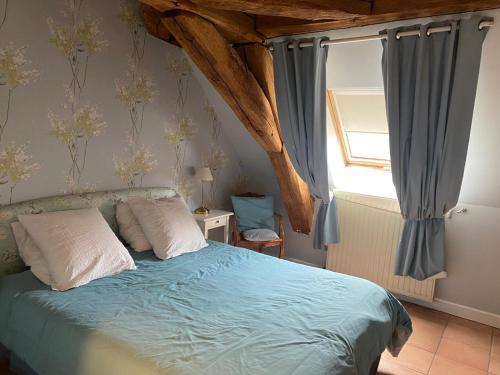 a bedroom with a bed with blue sheets and a window at Chateau de Plombières Maison Gauthier Dijon in Plombières-lès-Dijon
