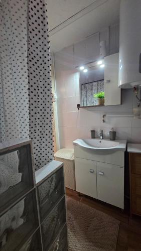 a small bathroom with a sink and a mirror at Estike Kerti Kuckó in Berekfürdő