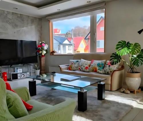 a living room with a couch and a coffee table at Hokkaido Hakodate Onuma National Park Kenzo's House in Ōnuma