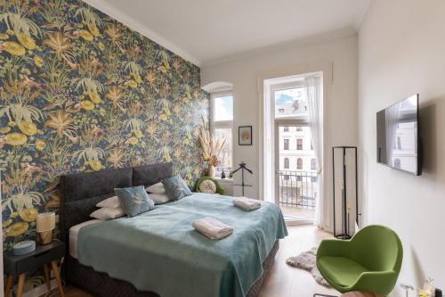 a bedroom with a bed and a green chair at V62 studio apartments- Downtown Sopron in Sopron