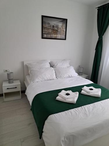a bedroom with a bed with towels on it at Mia Apartments in Craiova