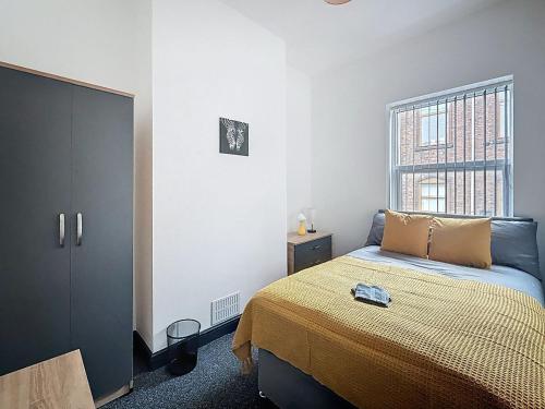 a bedroom with a bed and a window at PLUS Properties Eastwood 1 in Stoke on Trent