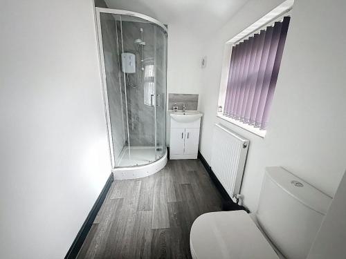 a bathroom with a shower and a toilet and a sink at PLUS Properties Eastwood 1 in Stoke on Trent