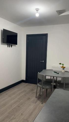 a room with a table and a black door at PLUS Properties Eastwood 1 in Stoke on Trent