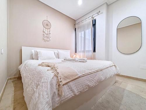 a white bedroom with a bed and a mirror at San Pedro Centro - 9110 in San Pedro del Pinatar