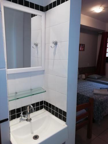 a bathroom with a sink and a mirror and a bed at Albergue Rio Vermelho in Salvador